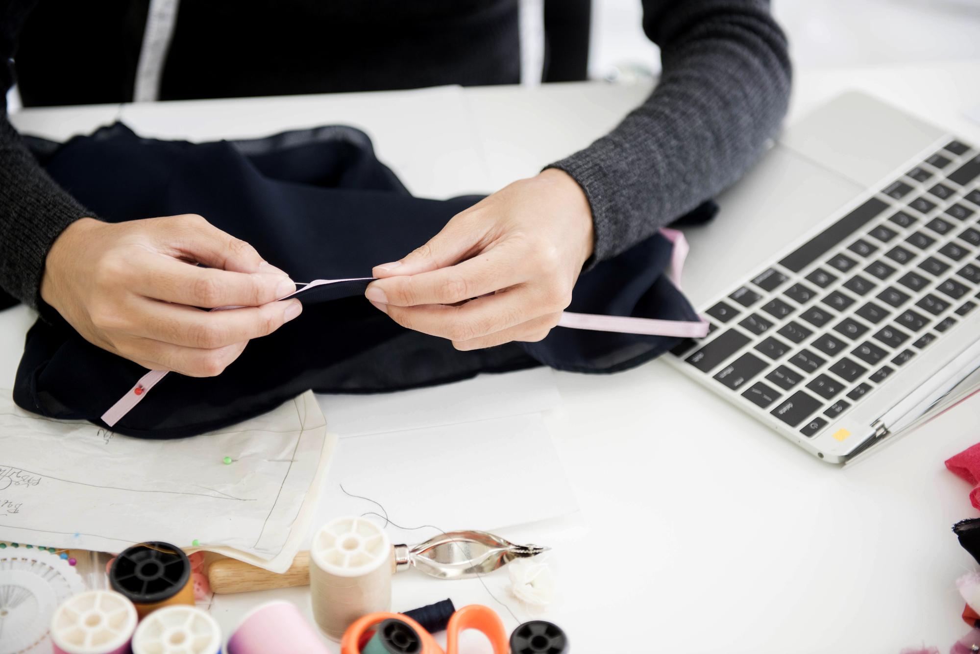 Artisan and laptop creating embroidered pattern