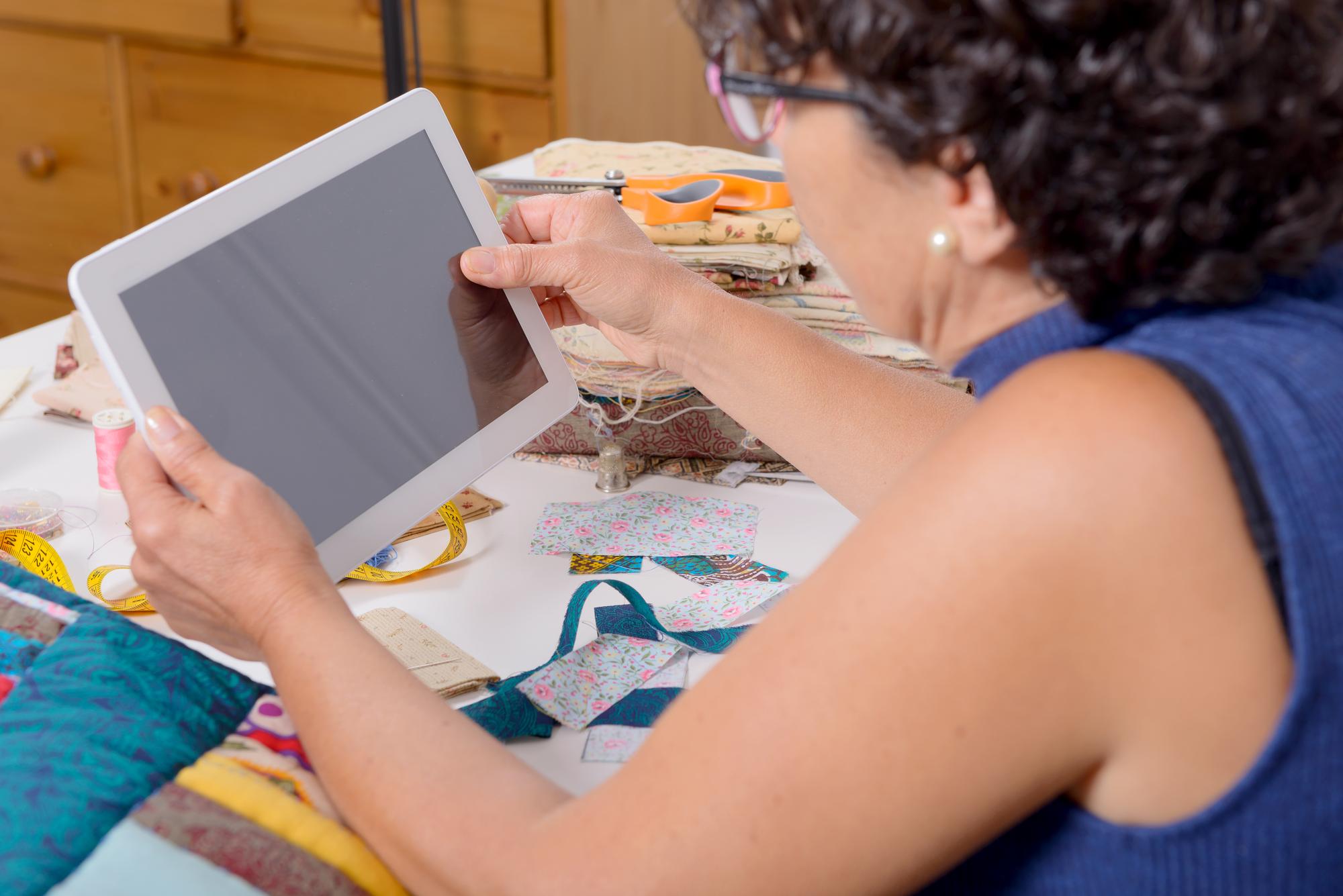 Instructor demonstrating embroidery on a digital tablet